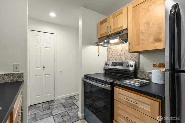 a kitchen with granite countertop a stove and a sink