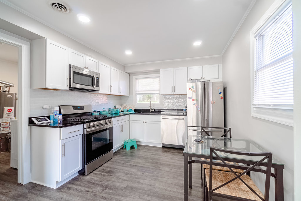 172 Monee Road Park Forest, IL 60466 - Photo 4 of 16 a kitchen with stainless steel appliances granite countertop a stove top oven a refrigerator a sink and a microwave