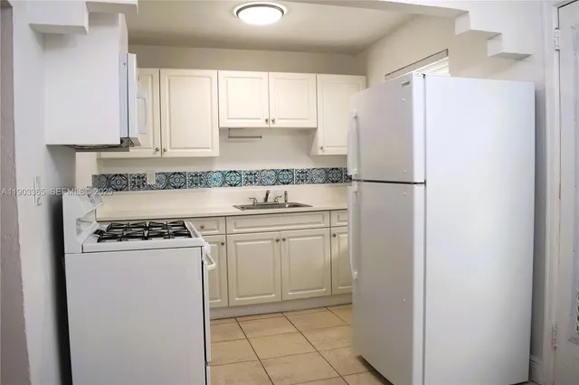 a kitchen with granite countertop wooden floors and white stainless steel appliances