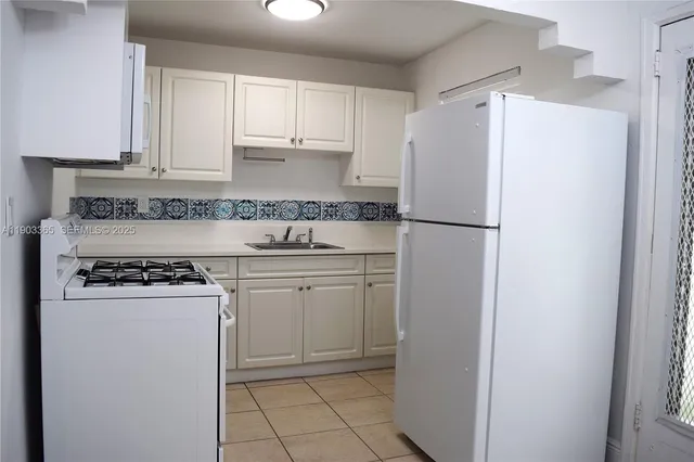 a kitchen with a sink a stove and cabinets