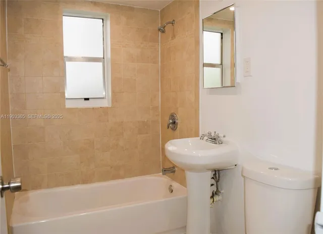 a bathroom with a sink a window and a shower