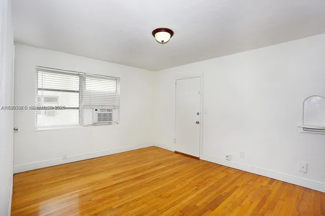 a view of a room with wooden floor and a window