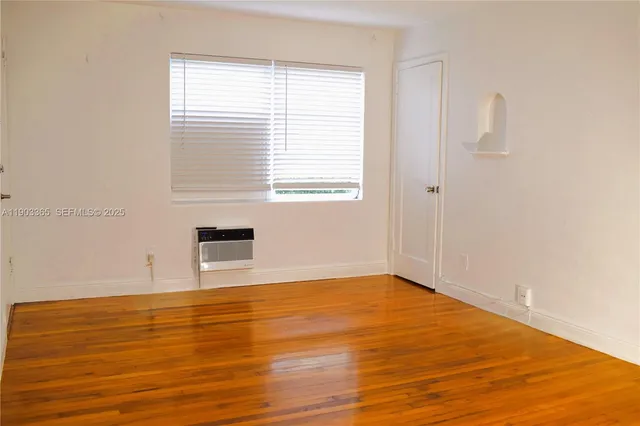 an empty room with wooden floor and closet