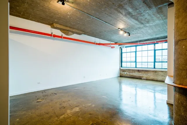 a balcony with wooden floor table and chairs