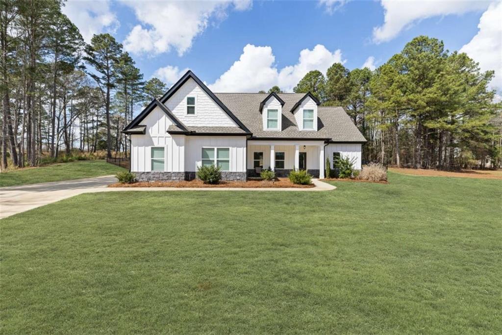 105 Capps Lane Eatonton, GA 31024 - Photo 1 of 65 a front view of a house with a garden and trees