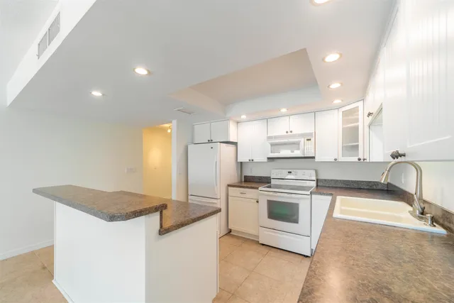 an empty room with chandelier fan and windows