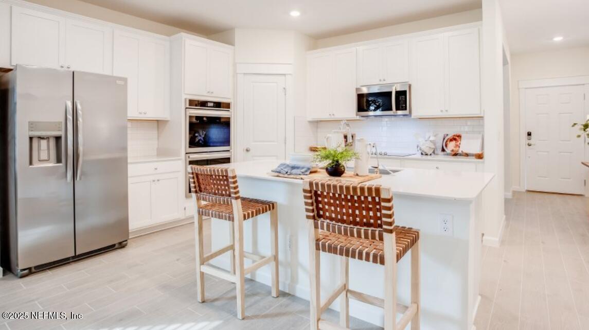 20 Neighbor Court St. Augustine, FL 32092 - Photo 62 of 71 a kitchen with stainless steel appliances kitchen island granite countertop a refrigerator and a stove top oven