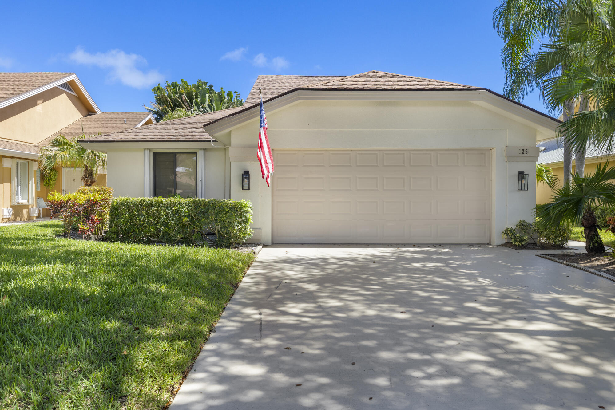 125 Cape Pointe Circle Jupiter, FL 33477 - Photo 2 of 45 a front view of a house with a yard and garage