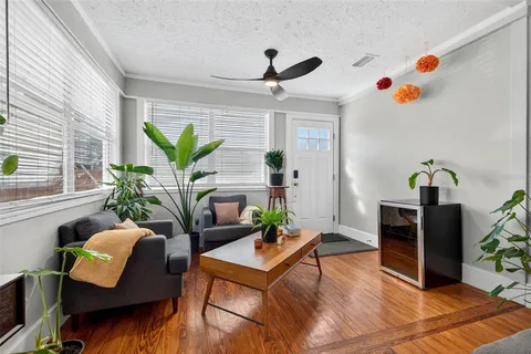 a living room with patio furniture and a potted plant