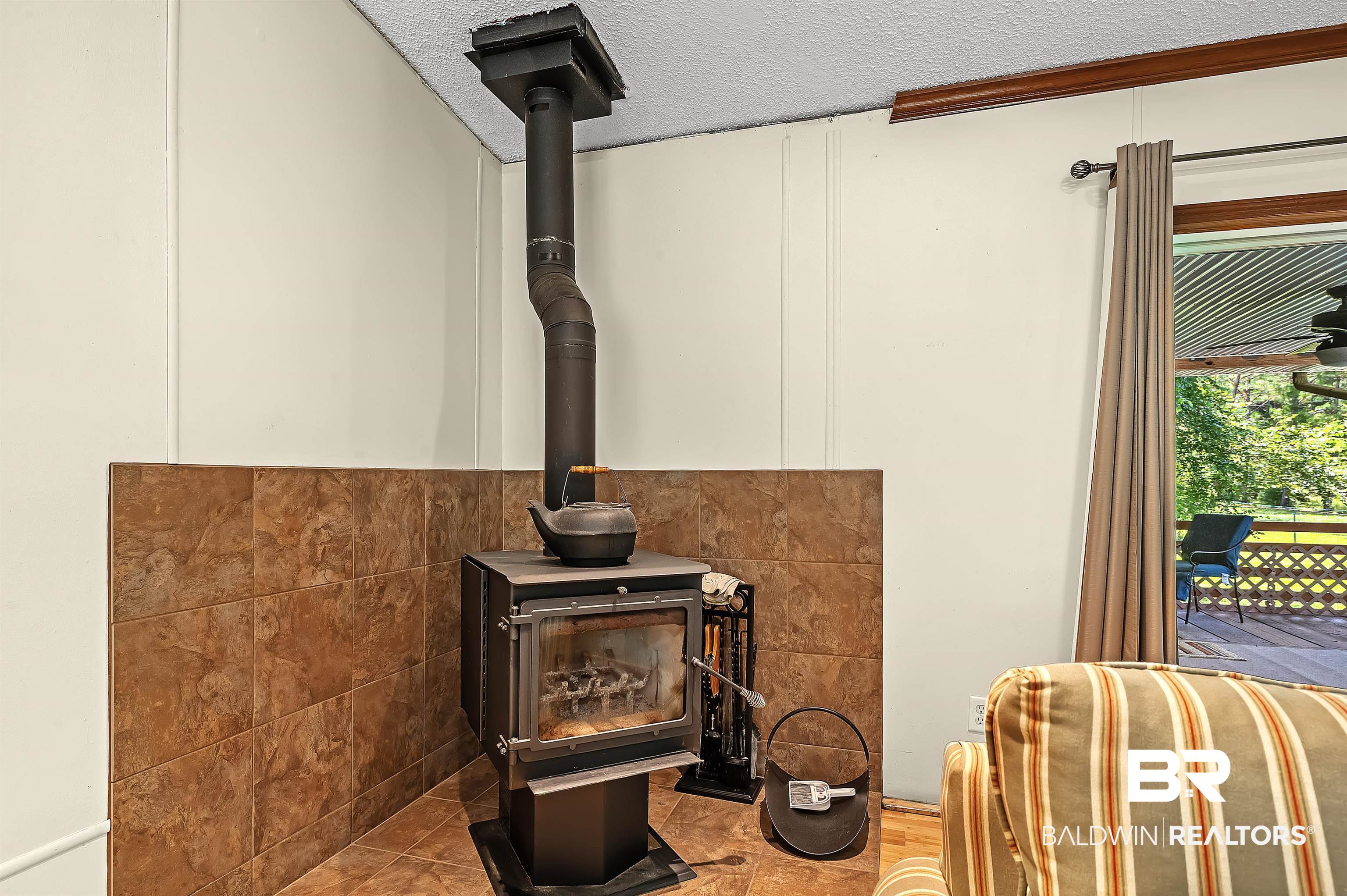 10970 Stucki Road Elberta, AL 36530 - Photo 19 of 56 Room details featuring a wood stove and a textured ceiling