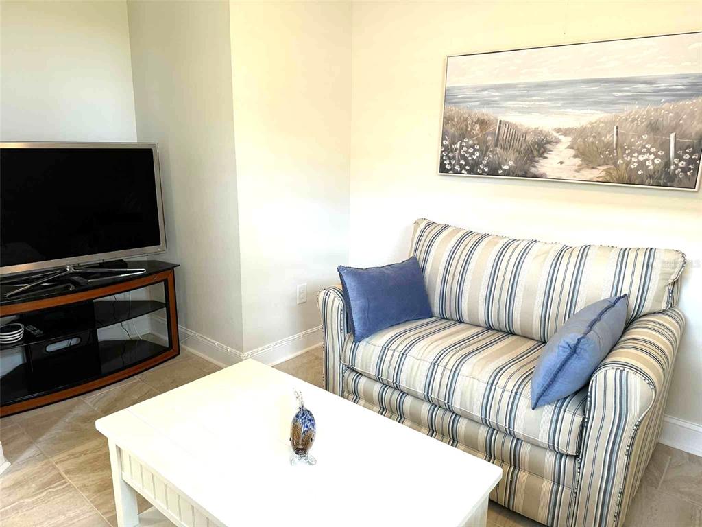19240 Isadora Street Venice, FL 34293 - Photo 23 of 41 a living room with a couch and a flat screen tv