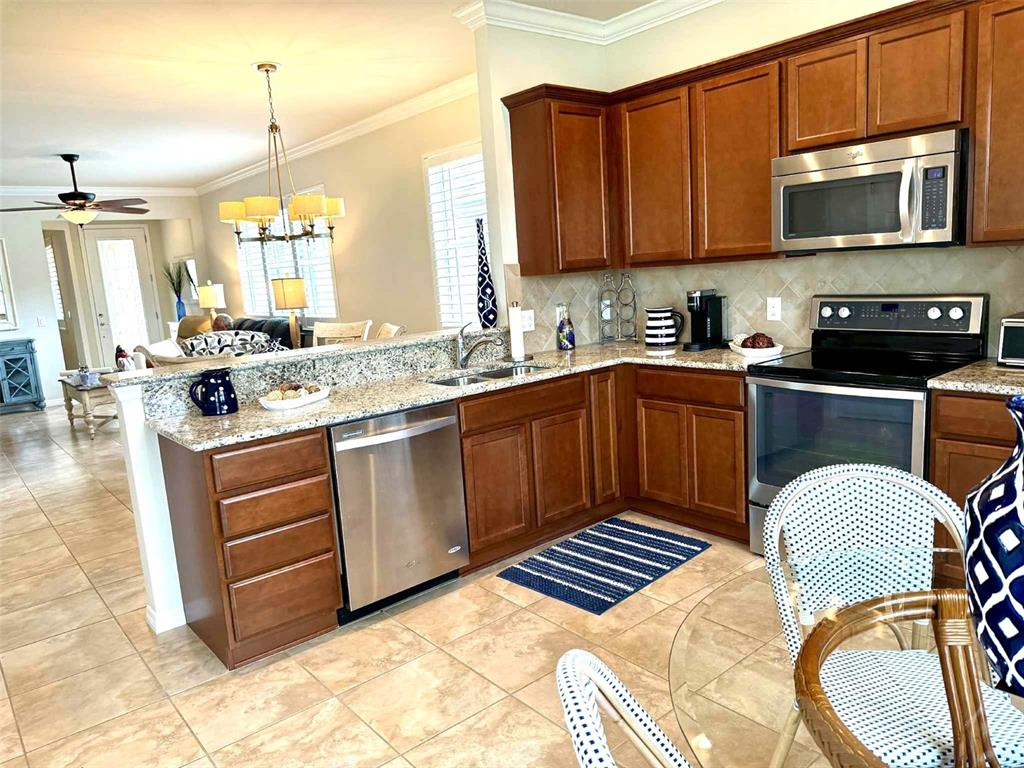 19240 Isadora Street Venice, FL 34293 - Photo 8 of 41 a kitchen with a stove a sink and a microwave