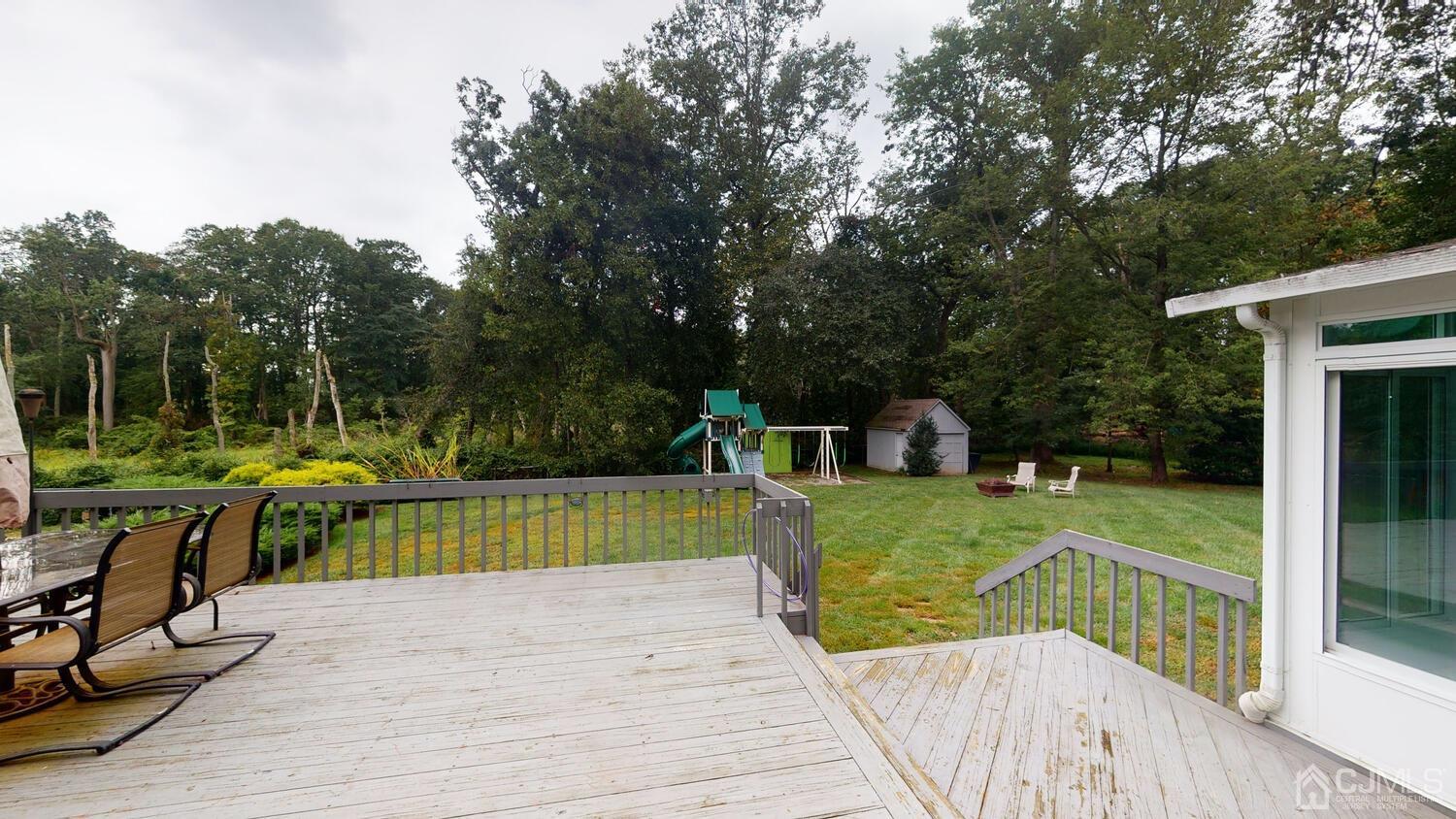 49 Brookside Road Millstone Township, NJ 08510 - Photo 47 of 60 a view of a wooden deck and a big yard with swimming pool
