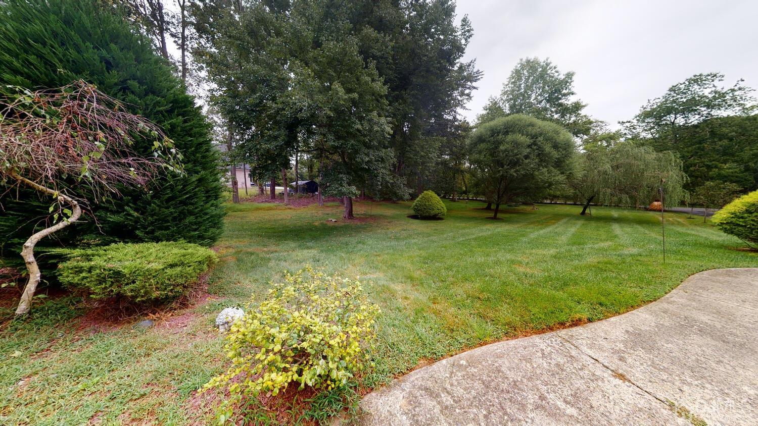 49 Brookside Road Millstone Township, NJ 08510 - Photo 52 of 60 a view of a garden with a bench