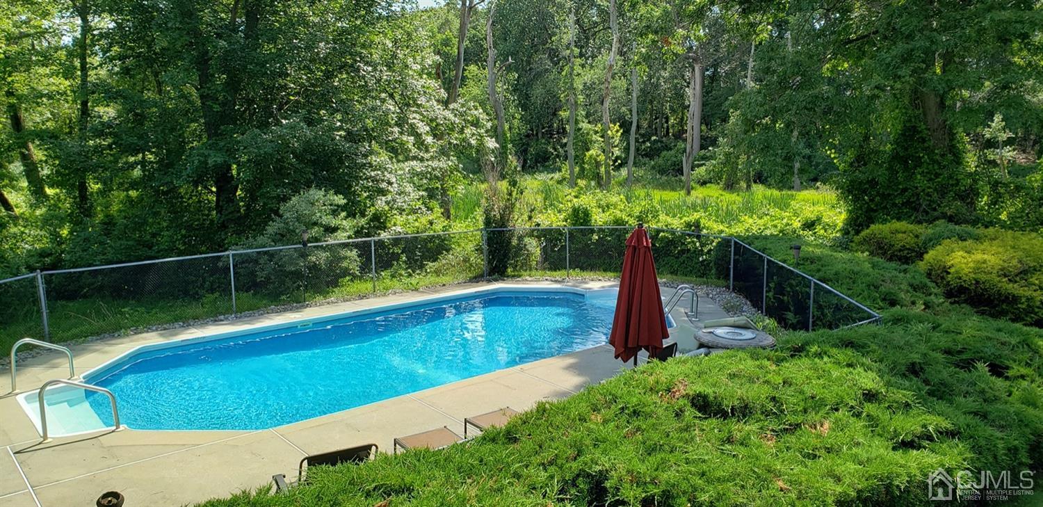49 Brookside Road Millstone Township, NJ 08510 - Photo 60 of 60 a view of a backyard with swimming pool and large trees