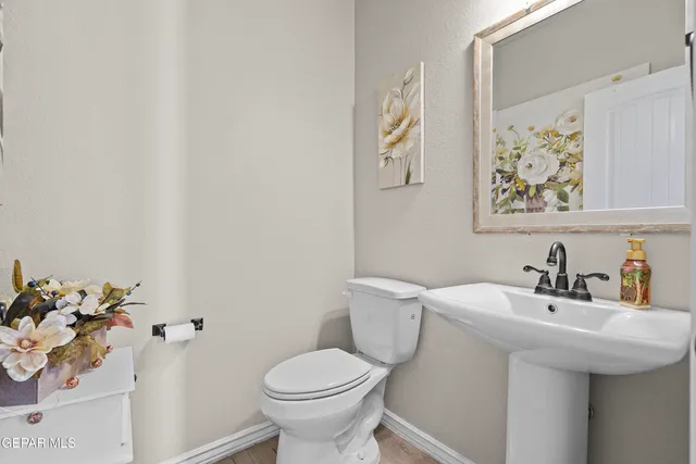 a bathroom with a sink mirror and toilet