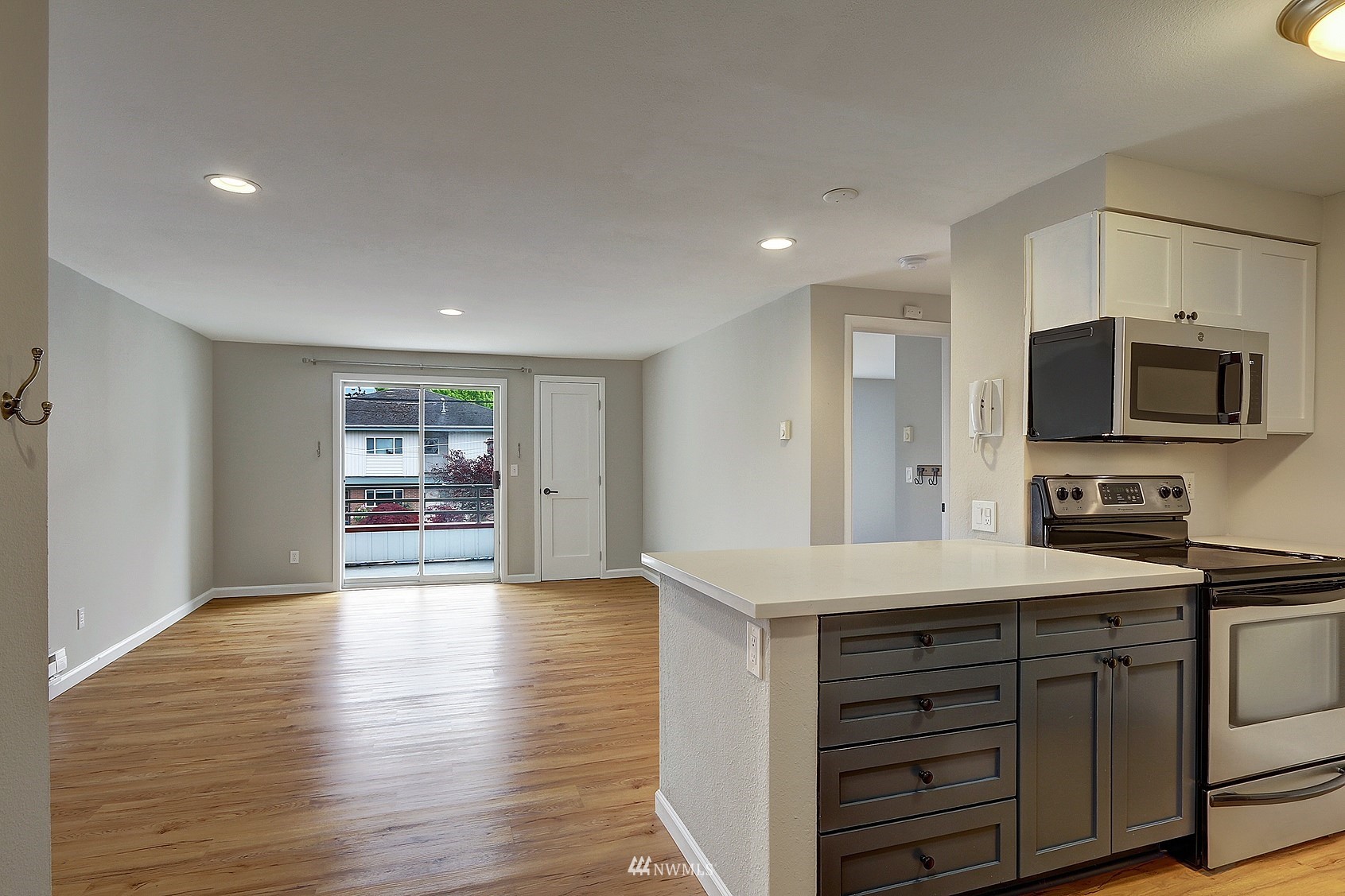 1124 North 92nd Street, Unit 101 Seattle, WA 98103 - Photo 3 of 14 a kitchen with stainless steel appliances a stove microwave and cabinets