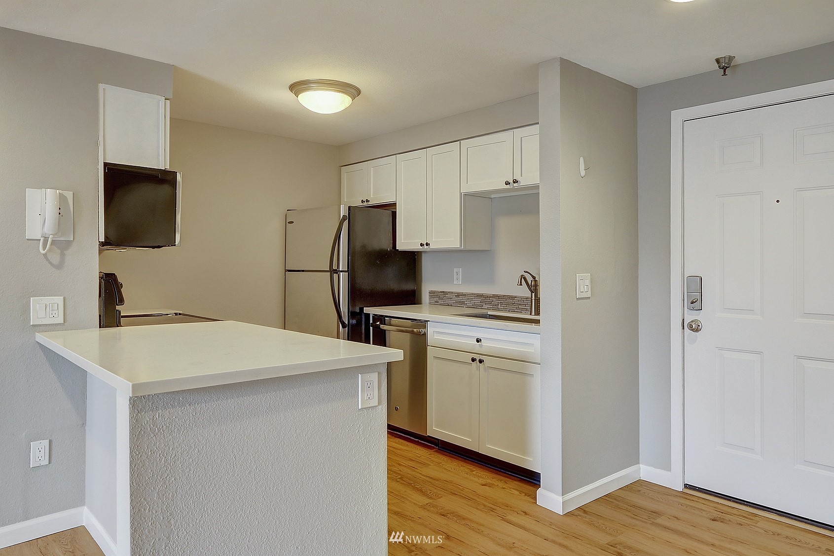 1124 North 92nd Street, Unit 101 Seattle, WA 98103 - Photo 4 of 14 a kitchen that has a sink a refrigerator and a stove top oven