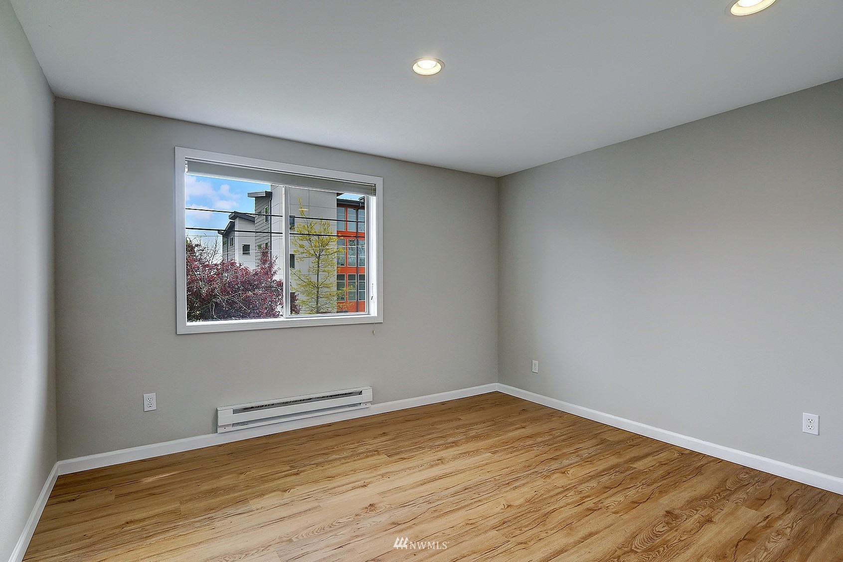 1124 North 92nd Street, Unit 101 Seattle, WA 98103 - Photo 7 of 14 a view of an empty room with wooden floor and a window
