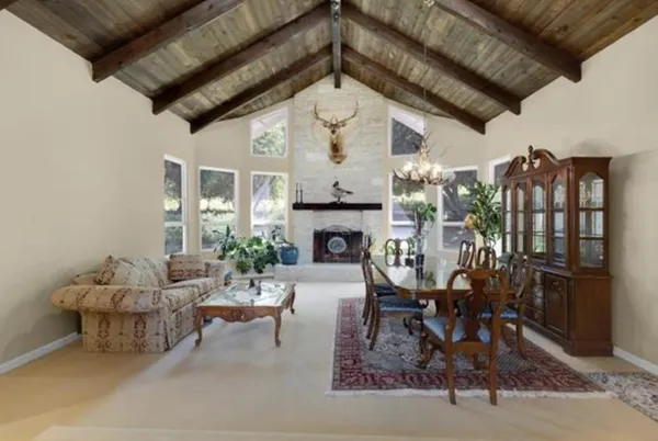 a living room with furniture a fireplace and a dining table with wooden floor