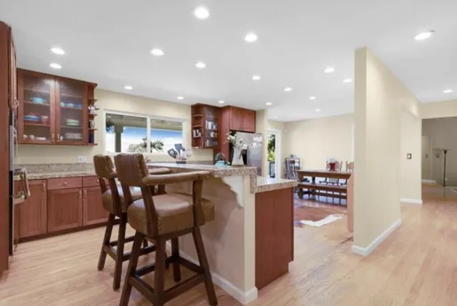 a living room with stainless steel appliances kitchen island granite countertop furniture and a wooden cabinets