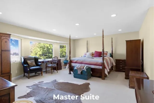 a spacious bedroom with a bed a table and a flat screen tv