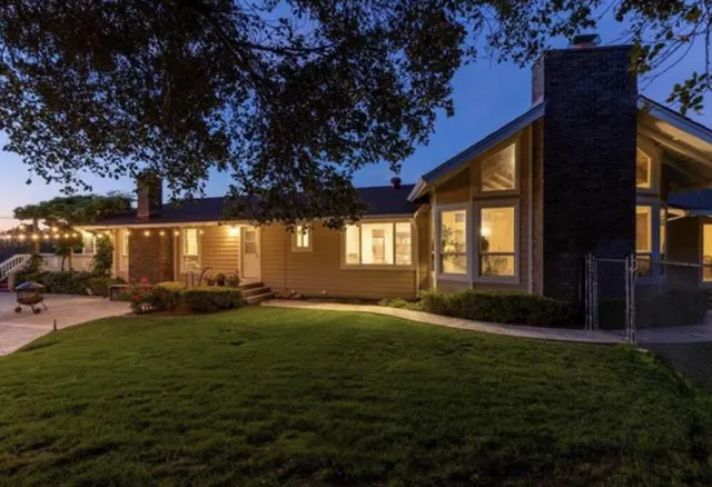 a backyard of a house with table and chairs and potted plants