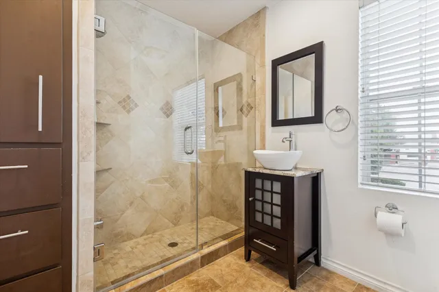 a bathroom with a shower a sink and a mirror