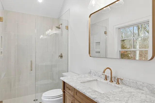a bathroom with a granite countertop sink toilet and shower