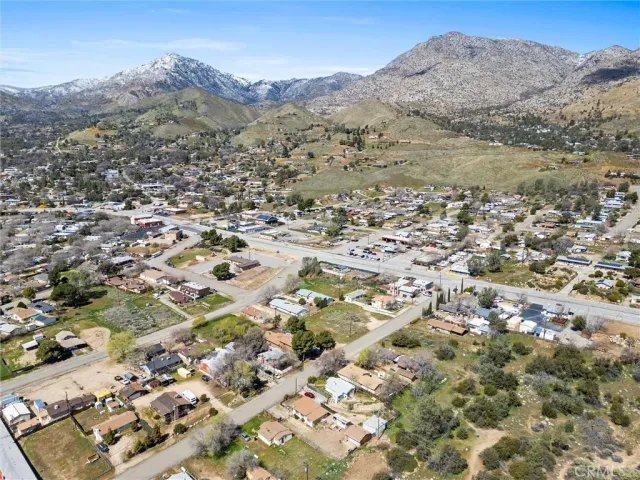 an aerial view of residential houses with outdoor space and trees