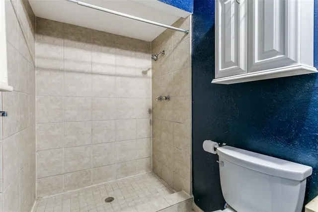 a bathroom with a toilet and a shower