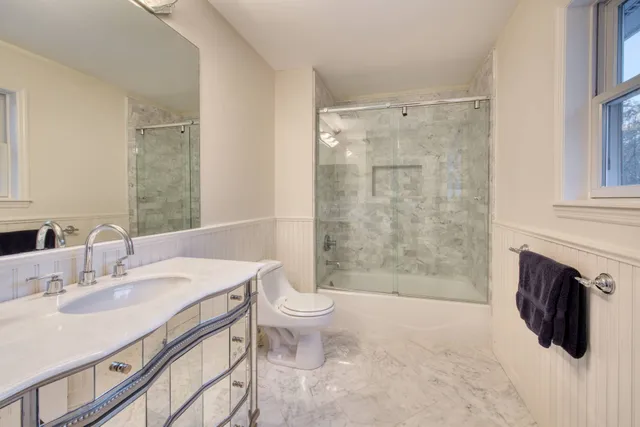 a bathroom with a sink toilet a mirror and shower