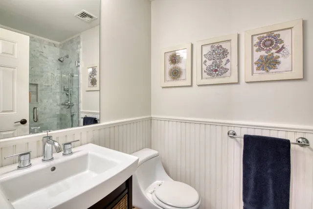 a bathroom with a sink vanity mirror and toilet