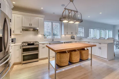 a kitchen with kitchen island stainless steel appliances a stove a sink and a refrigerator