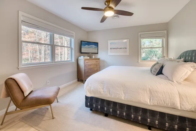 a bedroom with a bed chair and window
