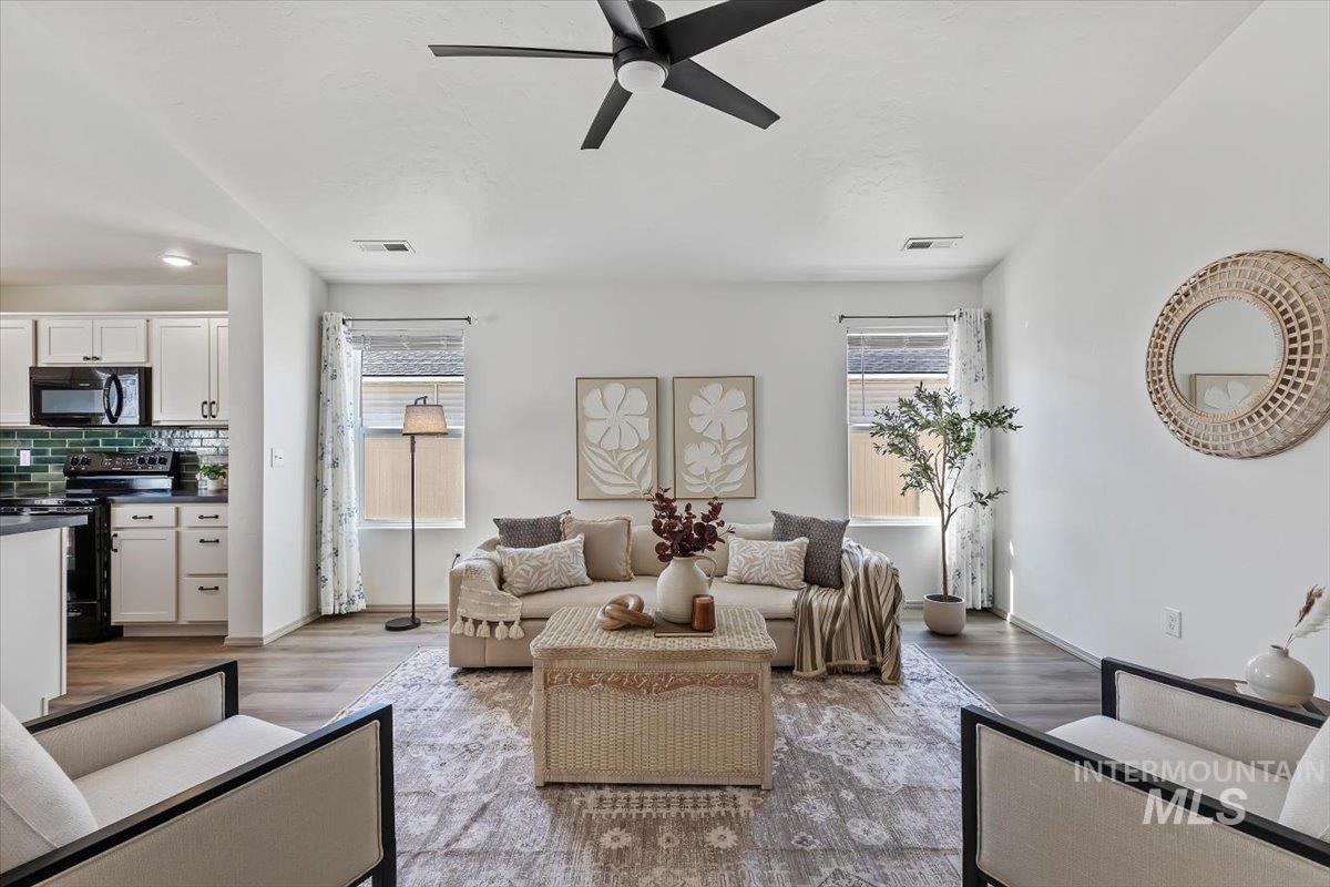12781 Ashfield Street Caldwell, ID 83607 - Photo 3 of 30 Living area featuring a ceiling fan, healthy amount of natural light, and light wood-style flooring