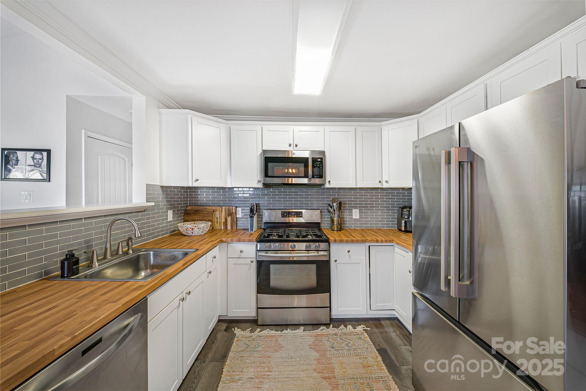 16 Woodfield Road Arden, NC 28704 - Photo 11 of 41 a kitchen with granite countertop a refrigerator stove and sink