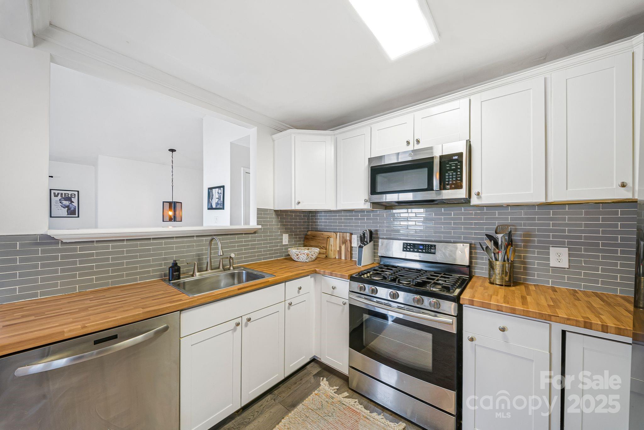 16 Woodfield Road Arden, NC 28704 - Photo 13 of 41 a kitchen with stainless steel appliances granite countertop a sink stove and microwave