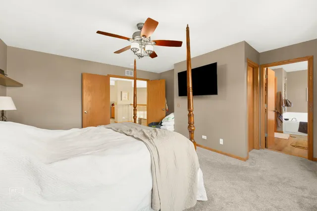 a bedroom with a large bed and a flat screen tv