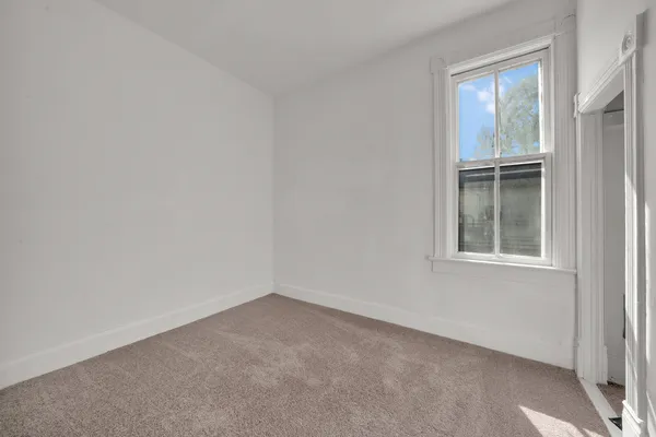 a bed sitting in a bedroom next to a window
