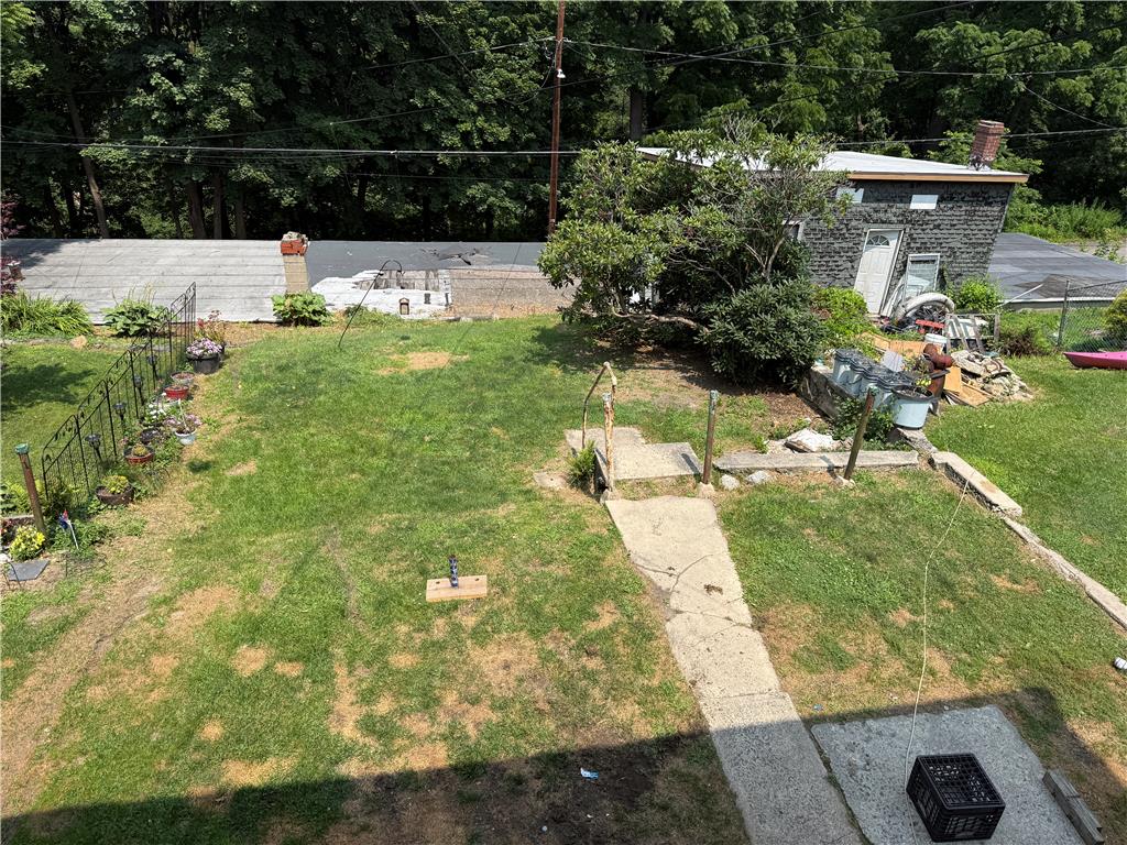 41 West Ridge Street Lansford, PA 18232 - Photo 14 of 40 A verdant backyard offers ample space, complete with a functional shed and mature trees.