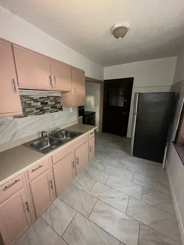 a kitchen with granite countertop white cabinets and refrigerator
