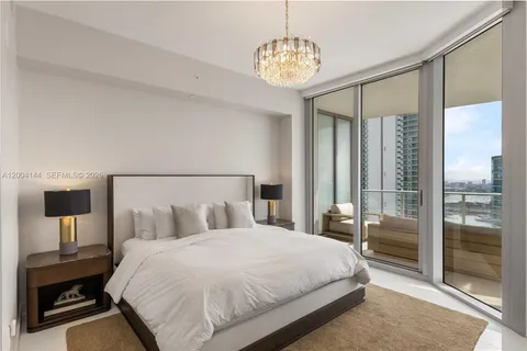 a bedroom with a large bed and a chandelier
