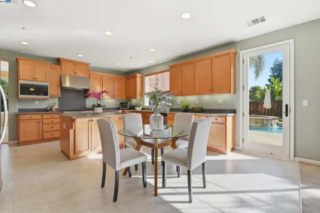 a living room with furniture kitchen view and a large window