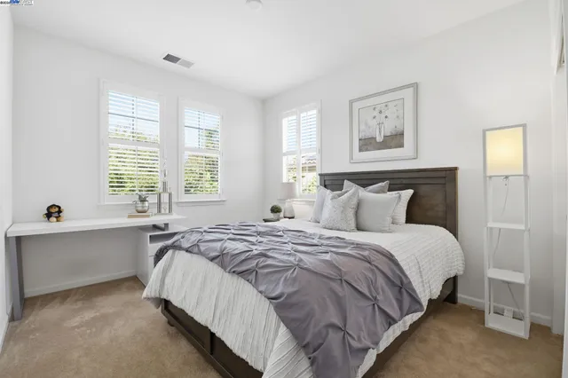 a spacious bedroom with a bed and a chandelier