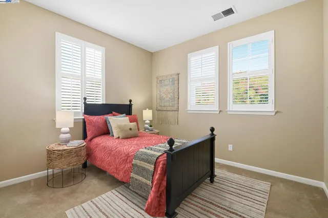 a bedroom with a bed and a large window