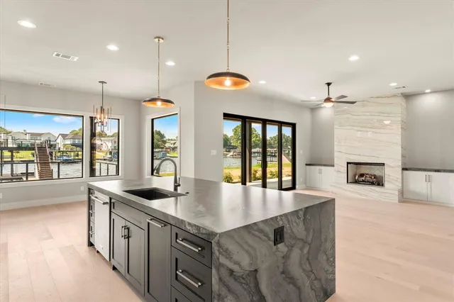 a kitchen with stainless steel appliances granite countertop a sink a stove and a wooden floors