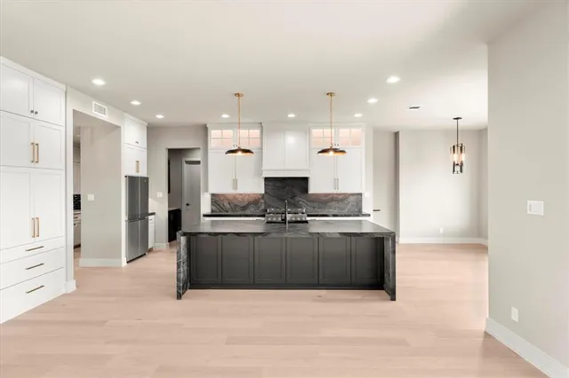 a large kitchen with stainless steel appliances kitchen island a large counter top and a stove top oven