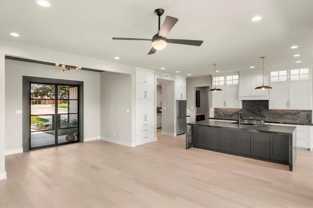 a large kitchen with stainless steel appliances granite countertop a stove and a refrigerator