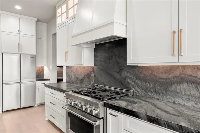 a kitchen with granite countertop a stove and a refrigerator